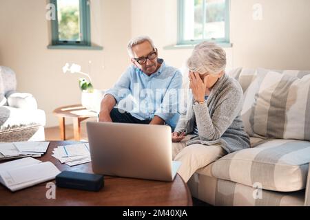 Share the problem solving instead of the stress. a senior couple having a disagreement while going through paperwork at home. Stock Photo