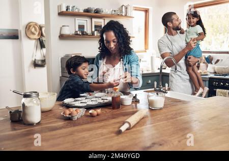 A dysfunctional family is any family with more than one person in it. a young couple baking at home with their two children. Stock Photo