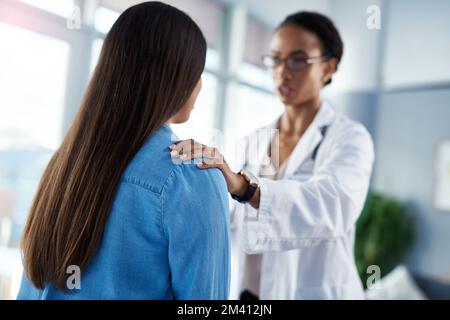 Doctors who practice compassion make a difference. a young doctor comforting her patient during a consultation. Stock Photo