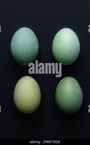Happy Easter background. DIY dyed shades of blue Easter eggs on black background abstract minimal concept. Stock Photo