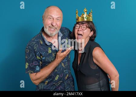 Happy together. Mature couple laughing. Long marriage in love funny moments. Crown on the head of his wife. Stock Photo