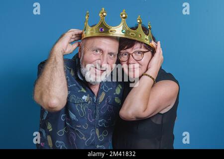 Long marrige funny moment. Elderly couple in love enjoing with crown on their heads. Happy together. Stock Photo