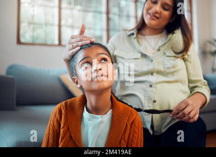 Hair care, grooming and pregnant woman with a child for love, care and thinking in the living room. Hair styling, happy and mother with a girl kid for Stock Photo