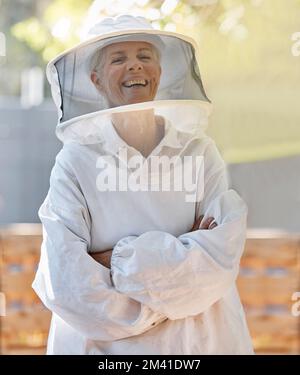 Beekeeper farmer and happy portrait of woman with cheerful smile in expert ppe and safety uniform. Happiness, pride and confidence of mature Stock Photo