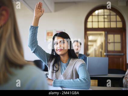 Classroom, woman and students hand for learning at university, ask question and studying for education. Indian woman, college scholarship and arm in Stock Photo
