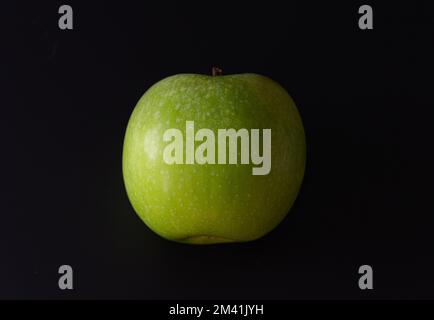 Green apple on a black background. Close-up Stock Photo