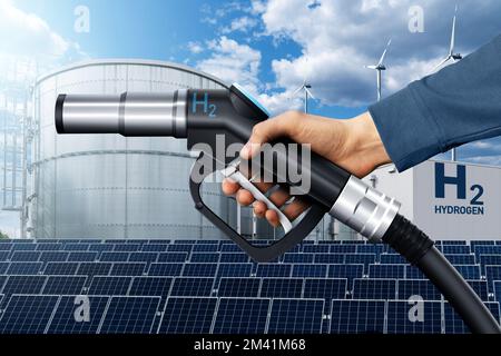Hand with hydrogen fueling nozzle on a background of H2 factory. Hydrogen production from renewable energy sources concept Stock Photo
