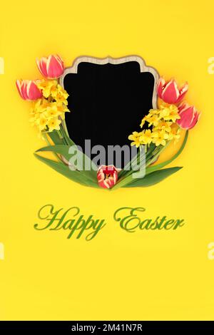 Happy Easter tulip and narcissus flower wooden frame with chalkboard on yellow background. Spring and Mothers Day creative nature floral border Stock Photo