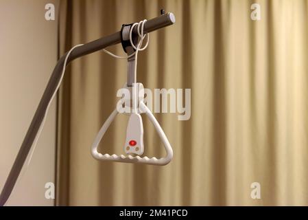 Hospital bed pull-up device with a button of an emergency bell Stock Photo