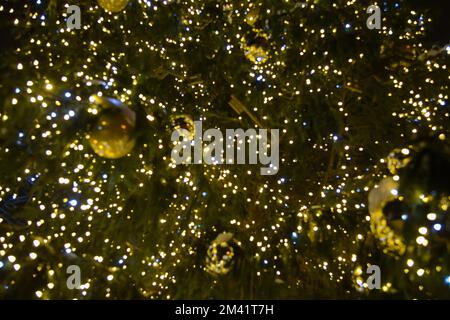 defocused Christmas tree with Christmas lights and decorations. Stock Photo