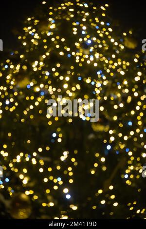 Colorful Red, Yellow and Green Christmas Tree Bokeh background of de focused glittering lights, Christmas background pattern concept. Stock Photo