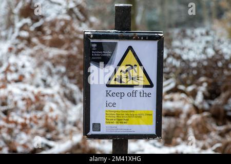 Farnham Common, Buckinghamshire, UK. 17th December, 2022. A Keep off the ice sign near a pond. The woodlands at Burnham Beeches in Buckinghamshire continued to look like a winter wonderland today as snow remained on the trees and the ponds were frozen over. Burnham Beeches is Site of Special Scientific Interest and a haven for wildlife. Temperatures are set to rise this week and heavy rain is forecast. Credit: Maureen McLean/Ģ����ý Live News Stock Photo