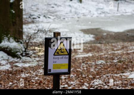 Farnham Common, Buckinghamshire, UK. 17th December, 2022. A Keep off the ice sign near a pond. The woodlands at Burnham Beeches in Buckinghamshire continued to look like a winter wonderland today as snow remained on the trees and the ponds were frozen over. Burnham Beeches is Site of Special Scientific Interest and a haven for wildlife. Temperatures are set to rise this week and heavy rain is forecast. Credit: Maureen McLean/Ģ����ý Live News Stock Photo