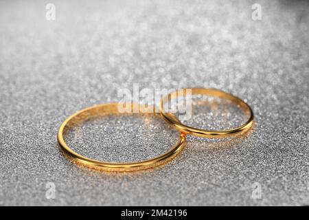 gold wedding rings for the wedding of the newlyweds lie on a light, shiny background. 3d render.. Stock Photo