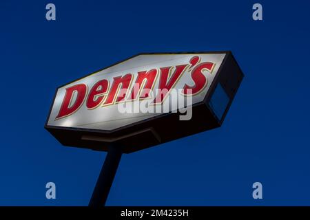 An Illuminated Denny’s pole sign with dark blue sky in the night is shown. Stock Photo