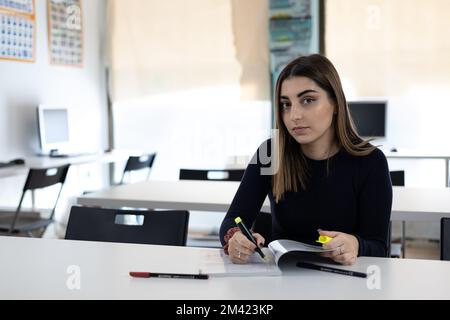 Student in classroom writing notes Stock Photo