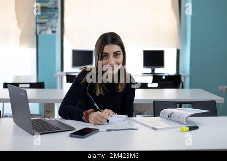 Student in classroom writing notes Stock Photo