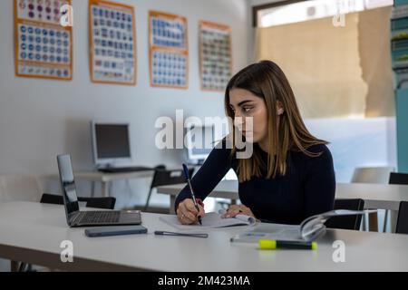 Student in classroom writing notes Stock Photo