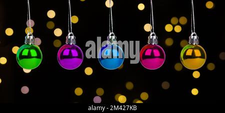 Christmas baubles, small balls of different color on dark background with Xmas lights. High quality photo Stock Photo