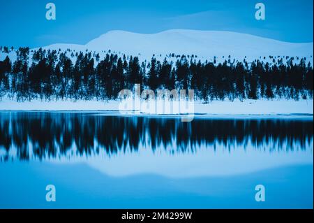 Reflection of snow covered mountain Stock Photo