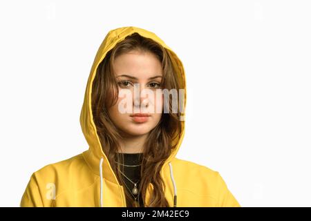 Long hair pretty young woman with noze ring. Covered head yellow raincoat with hood. isolated portrait. Stock Photo