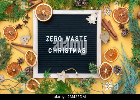 Zero waste Christmas concept. Natural materials wood, paper, fir branches, cones, nuts, dried citrus fruits, cinnamon. Frame with an inscription. Eco- Stock Photo