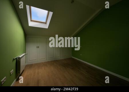 Room in the attic floor with ceilings with skylights and small closets with white doors in the wings Stock Photo