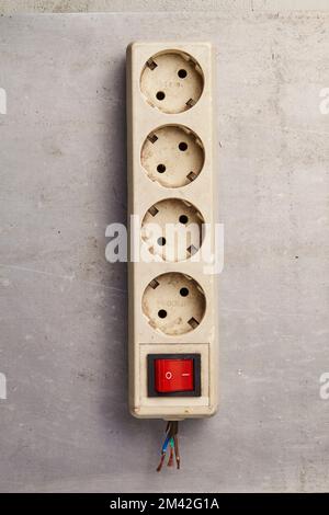 Jakarta, Indonesia - December 12, 2022 : A disconnected electrical plug with red switch on a grey floor Stock Photo