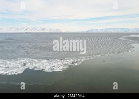 Open water at fjord in front of mountain range, Greenland. Stock Photo