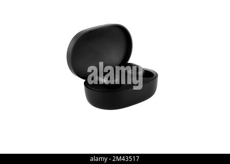 Wireless headphones on a white background. Close-up. Bluetooth headset in charging case. Stock Photo