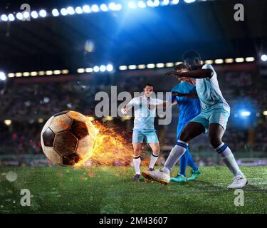 Football scene with competing football players at the full stadium with a fireball Stock Photo
