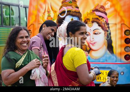 Young ladies on pilgrimage having fun doing their make up behind a beautifully painted bus outside the Ramanathaswamy Temple Stock Photo