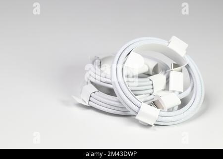 New white USB type charger cable, compatible for many devices, wrapped in a spiral shape, isolated on white background. Stock Photo