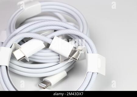 New white USB type charger cable, compatible for many devices, wrapped in a spiral shape, isolated on white background. Stock Photo