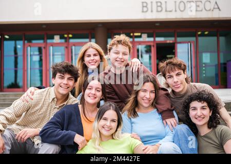 Group of university students resting in front of the library door Stock Photo
