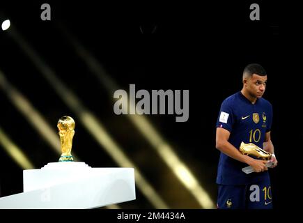 France's Kylian Mbappe walks past the FIFA World Cup trophy after being presented with The Golden Boot following defeat in the FIFA World Cup final at Lusail Stadium, Qatar. Picture date: Sunday December 18, 2022. Stock Photo