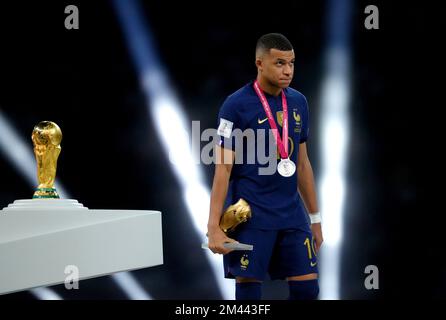 France's Kylian Mbappe walks past the FIFA World Cup trophy after being presented with his second place medal following defeat in the FIFA World Cup final at Lusail Stadium, Qatar. Picture date: Sunday December 18, 2022. Stock Photo