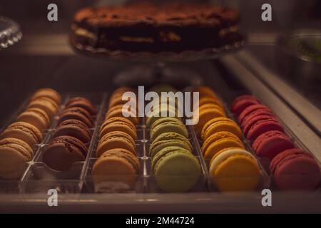 multi-colored macaroons red, yellow, blue, green, orange colors on the counter in the store. Stock Photo