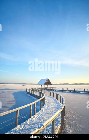 curved footbridge over frozen lake in Hemmelsdorf, northern Germany. High quality photo Stock Photo