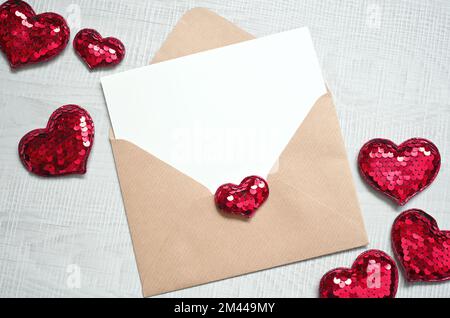 Blank white greeting card with brown envelop and hearts on marble table. Mockup valentines day concept Stock Photo