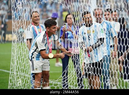 Argentina's Paulo Dybala cuts the net as he celebrates victory following the FIFA World Cup final at Lusail Stadium, Qatar. Picture date: Sunday December 18, 2022. Stock Photo