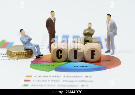 Business and finance concept. On financial reports with diagrams, figures of businessmen and wooden cubes with the inscription - CIF Stock Photo