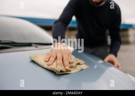 Happy young man washing his new car. Stock Photo