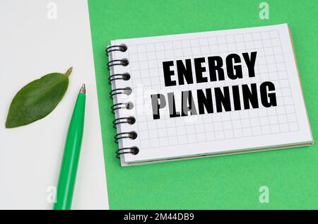 Ecological concept. On a white-green background lies a pen, a leaf of a plant and a notepad with the inscription - Energy Planning Stock Photo