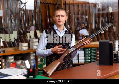 Gun shop salesman showing double barreled hunting rifle Stock Photo