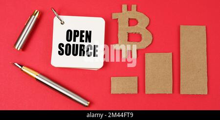 Business and bitcoin concept. On a red surface lie a bitcoin symbol, a graph, a pen and a notepad with the inscription - Open Source Stock Photo