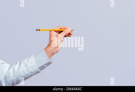 Male hand holding a pencil on a blank. Man fingers holding a pencil with blank space. Person hands holding a pencil on a space for text, Hand with a Stock Photo
