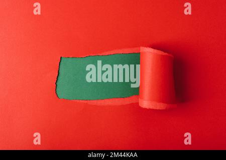 Hole in red paper on green background. Mockup. Stock Photo