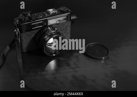 Retro camera on wood table background, vintage - black and white Stock Photo