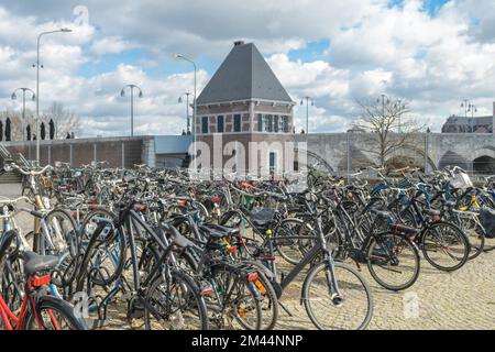 Maastricht. Limburg - Netherlands 10-04-2022. Public parking for bicycles near the canal in the city of Maastricht. View of the old tower Stock Photo